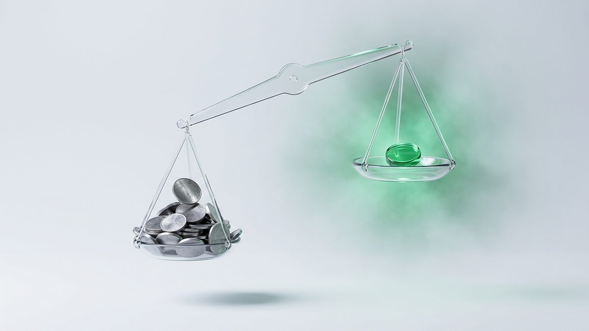 Two glass scale pans weighing a stack of coins against a single translucent one percent token